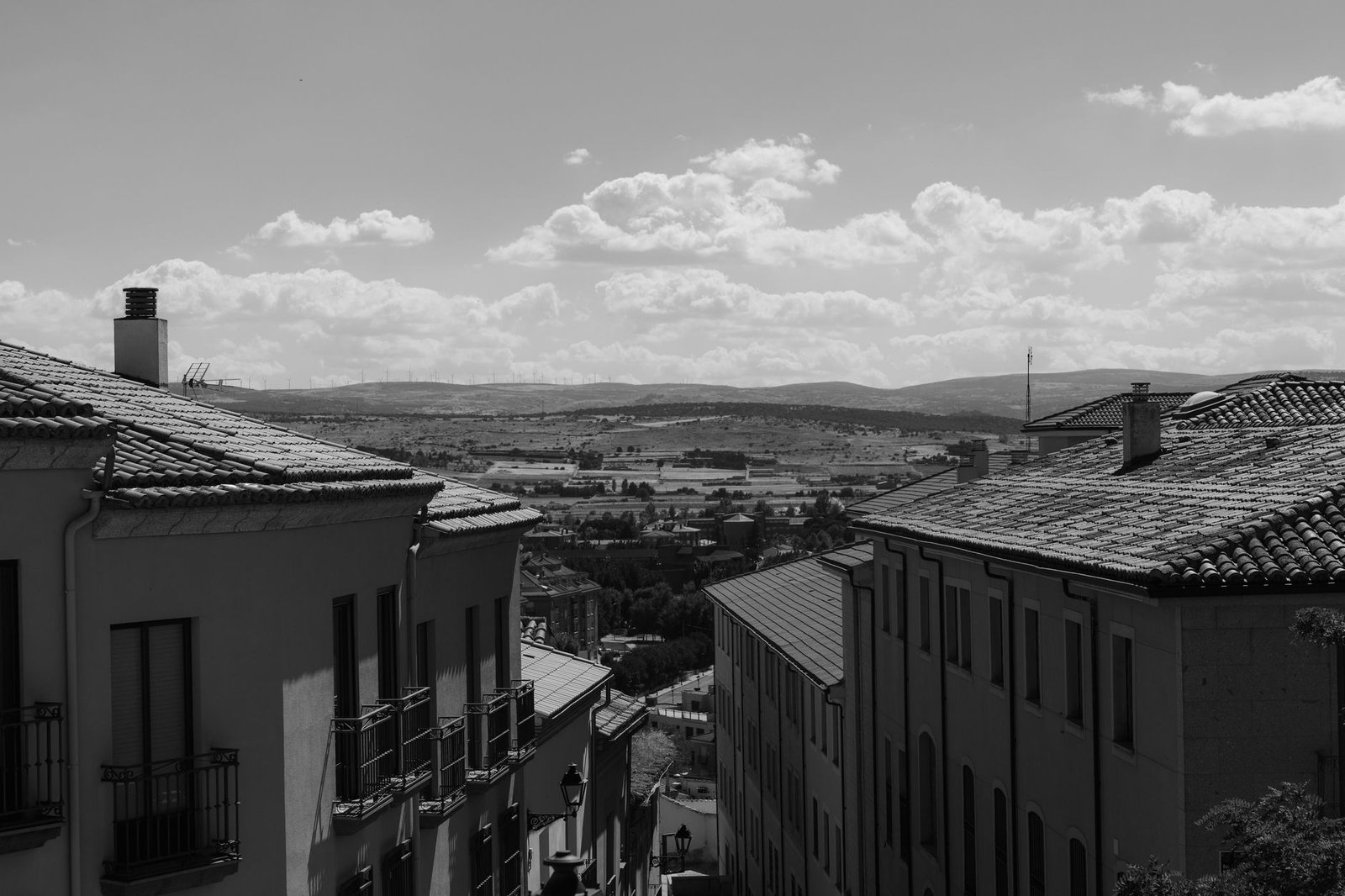 Tejados de teja y azoteas de un casco antiguo vistos desde arriba, en blanco y negro